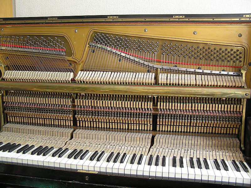 مکانیسم و سیم‌ها در پیانوهای ایستاده عمود بر کلیدها هستند. پوشش رشته ها برای این عکس حذف شده است.
